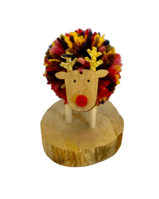 Cute Xmas smiling multicolour pompom reindeer on wooden base